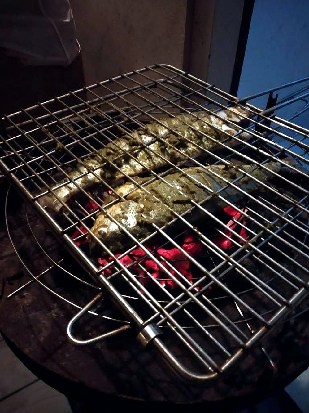 Fresh Kerala fish grilling over charcoal